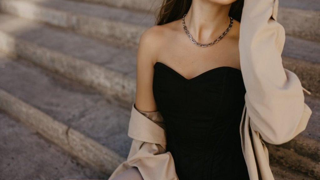 Žena v čiernom korzete a béžovom trenčkote – lingerie trend jeseň 2025