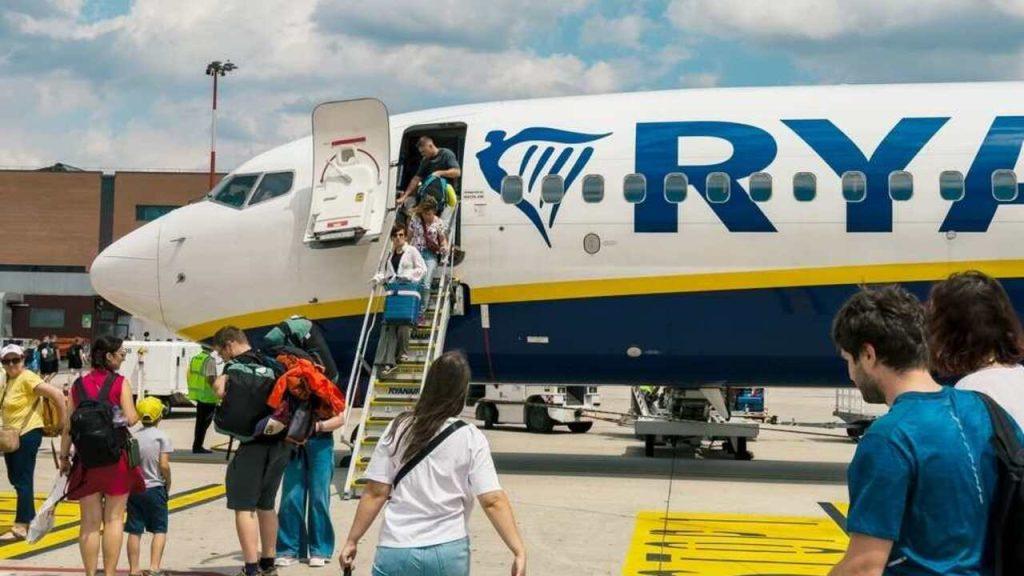 Cestujúci nastupujú do lietadla Ryanair na letisku s príručnou batožinou.