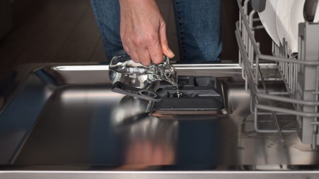 Nalievanie octu do priehradky umývačky riadu ako domáceho leštidla