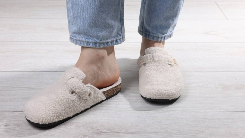 Mäkké domáce papuče na nohách ženy v obývačke