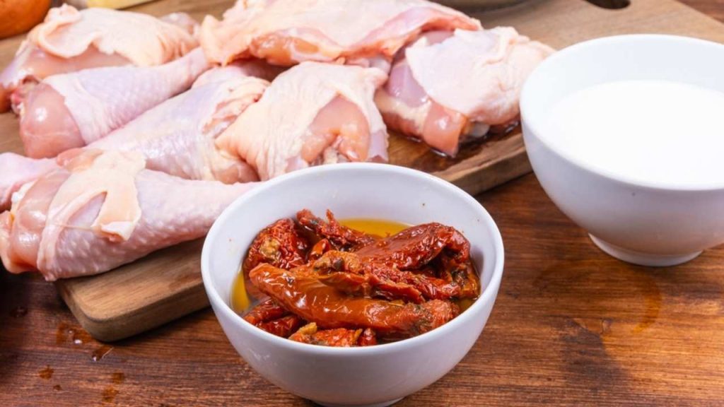 Ingrediencie na toskánske kurča: sušené paradajky v oleji, surové kuracie mäso a smotana