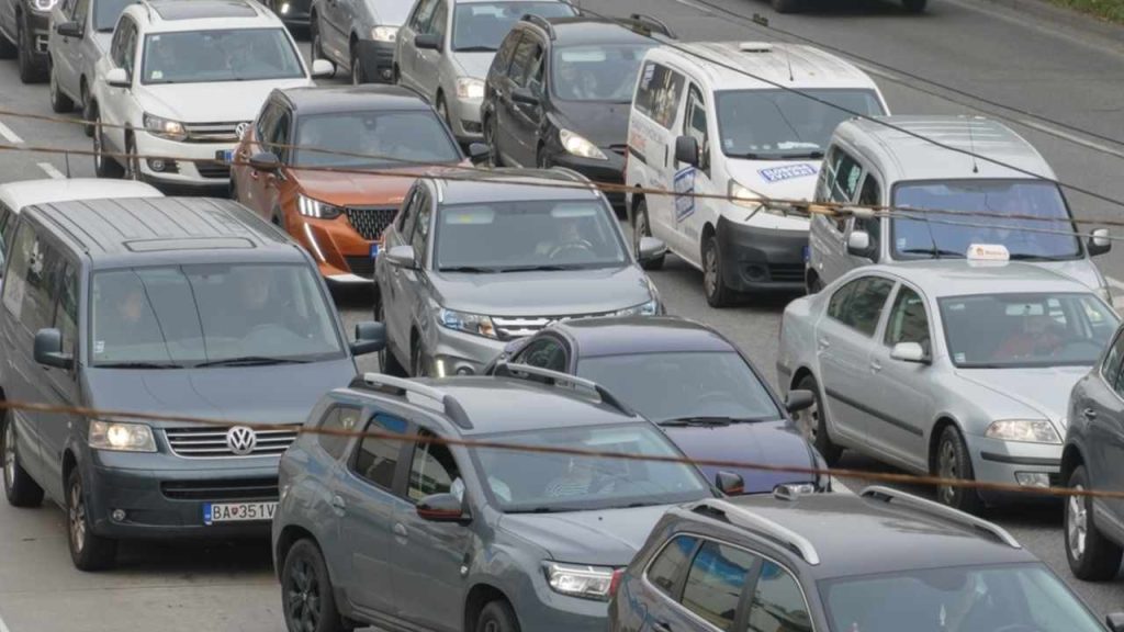 Premávka v rušnom európskom meste s osobnými autami.