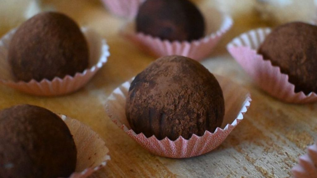 Mini tiramisu guľky obalené v kakau, elegantne uložené v papierových ozdobných košíčkoch.