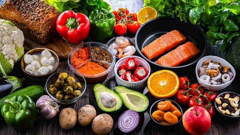 Stôl s čerstvou zeleninou, rybami, orechmi a olivovým olejom typickými pre stredomorskú diétu.