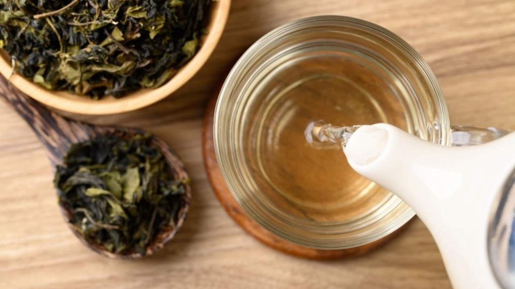 Nalievanie zeleného čaju z kanvice do šálky