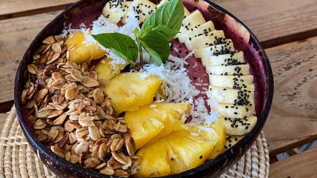 Smoothie miska s ananásom, banánom, granolou a kokosom, ozdobená čerstvou mätou