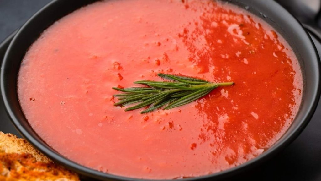Miska domácej paradajkovej polievky ozdobená bylinkami