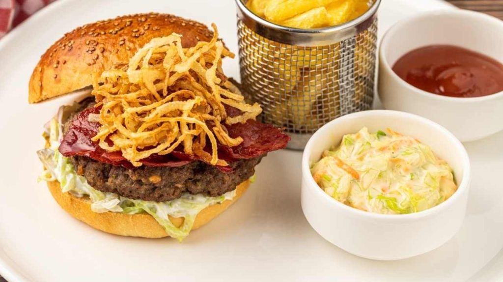 Domáci burger ozdobený pečenou cibuľou.