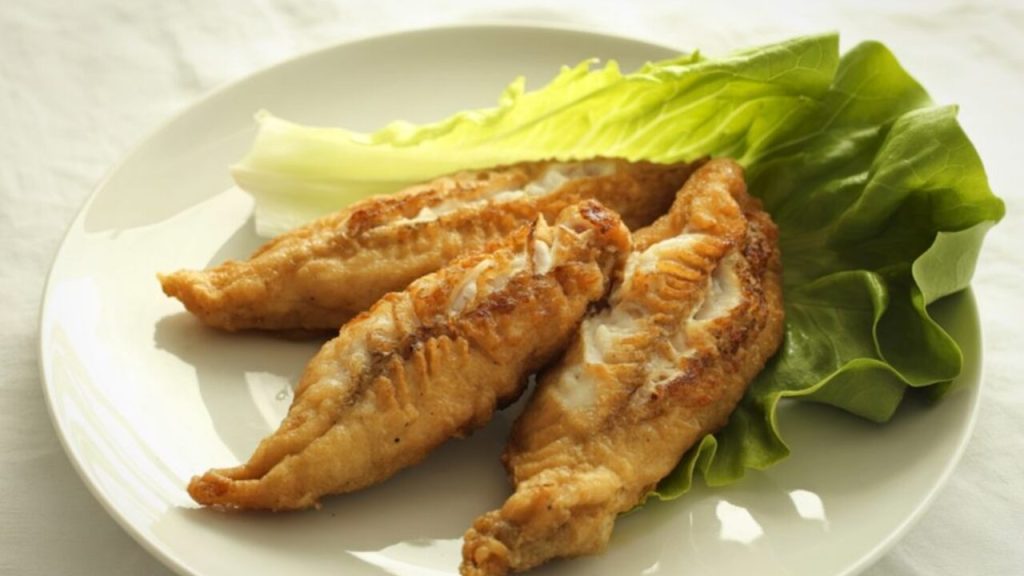 Chrumkavé vyprážané rybie filé servírované na listoch šalátu