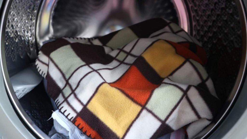 Deka vložená do práčky pripravená na šetrné pranie pri nízkej teplote.