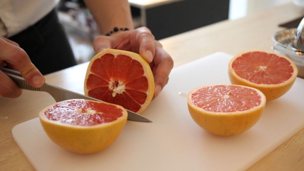 Žena krája grapefruit ako súčasť ranného rituálu.