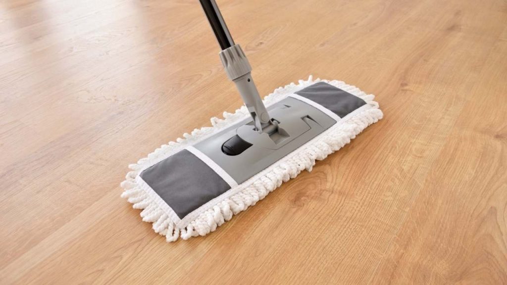 Mikrovláknový mop posúvajúci sa po čistej podlahe počas umývania.