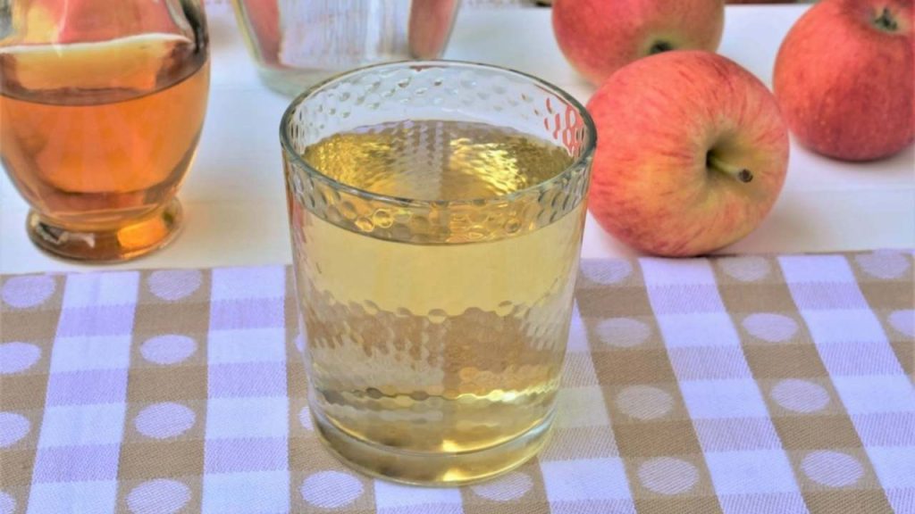 Pohár vody s jablčným octom na stole