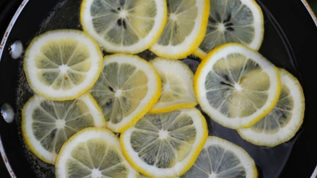 Citrónové plátky varené vo vode na panvici pri čistení pripáleného dna