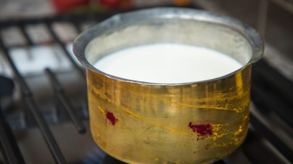 Teplé mlieko v hrnci pripravené na zmäkčenie vyschnutého syra