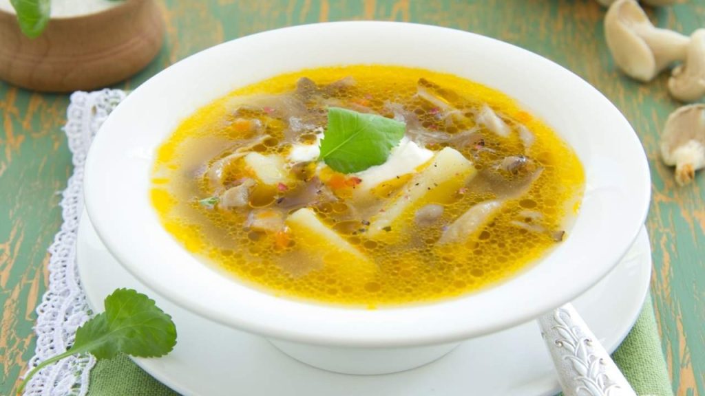 Hlivová polievka s kúskami húb, zemiakov a jemným korenistým vývarom podávaná v bielej miske.