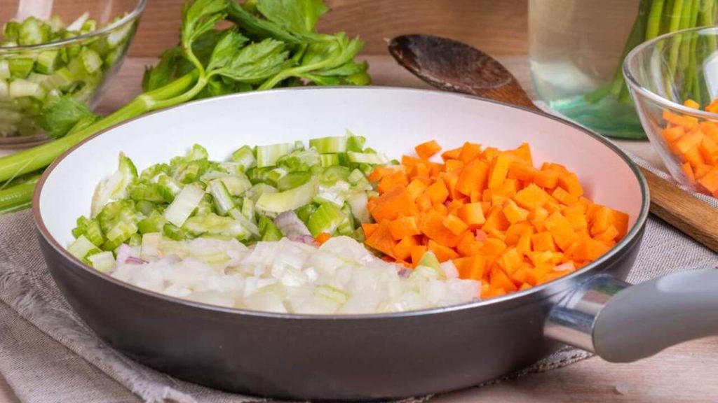 Nasekaná mrkva, cibuľa a stopkový zeler pripravené na panvici ako základ soffritto.