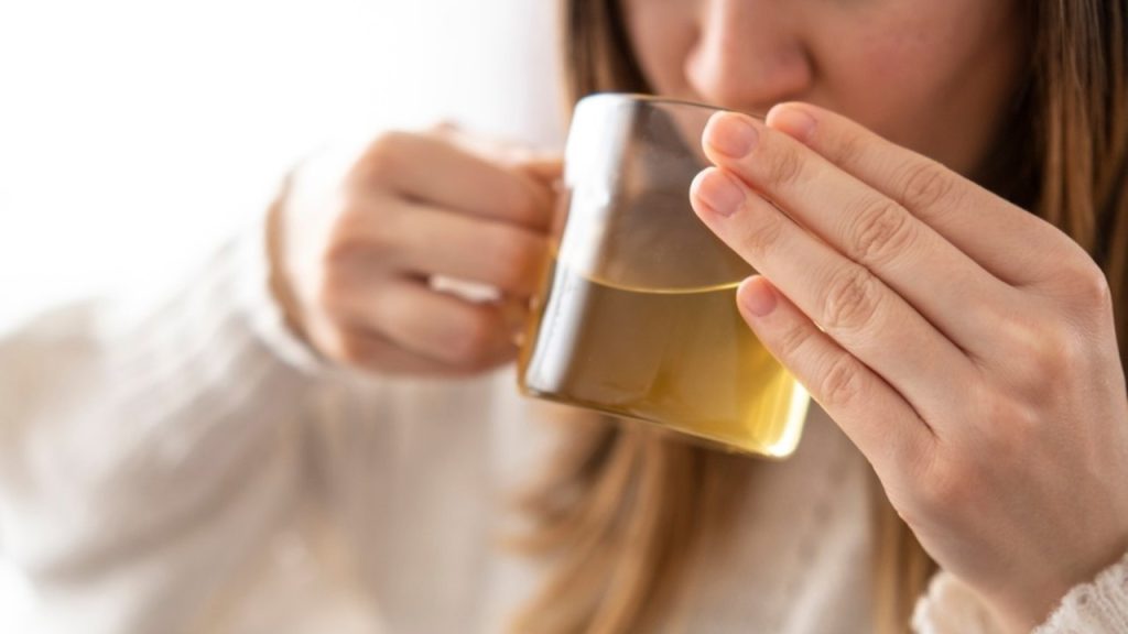 Žena pije zelený čaj po jedle