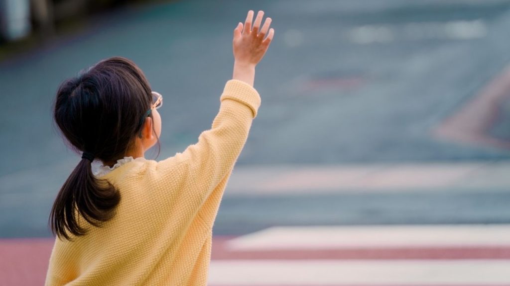 Dieťa zdvíha ruku na priechode pre chodcov ako gesto vďačnosti vodičovi