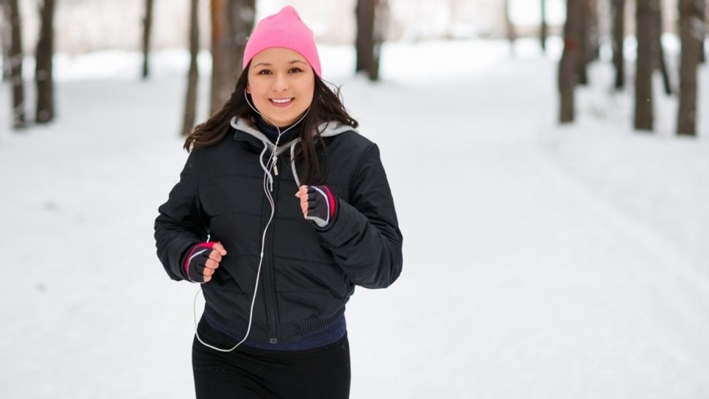 Žena behajúca v parku počas chladnejšieho počasia