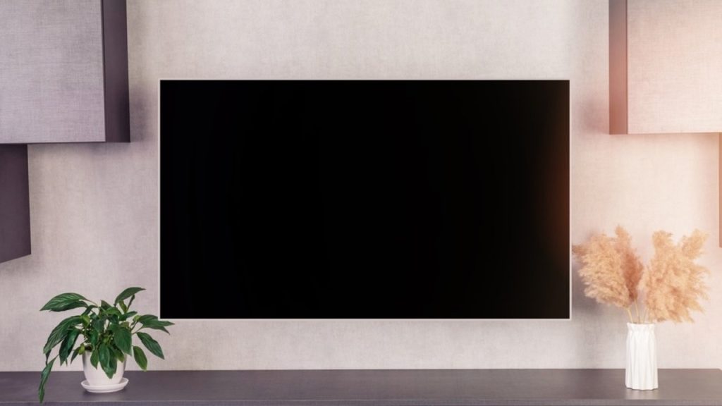 Veľký moderný televízor s prázdnou čiernou LCD obrazovkou zavesený na stene v interiéri domu