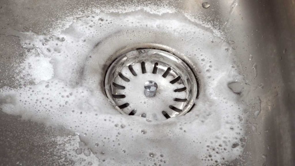 Reakcia sódy a octu v dreze vytvára penu, ktorá pomáha uvoľniť usadeniny.