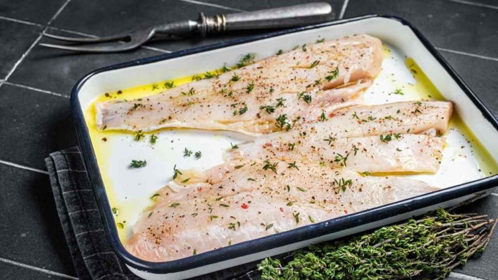 Surové rybie filé marinované v oleji a bylinkách pred tepelnou úpravou