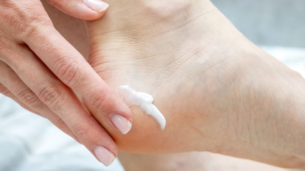Nanášanie krému na päty pred spaním s ponožkami
