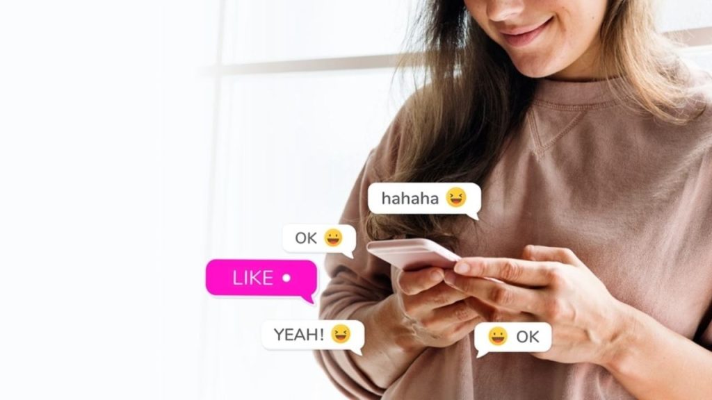 Žena si číta správu v mobile a usmieva sa, na obrazovke sú emotikony a reakcie zo správy