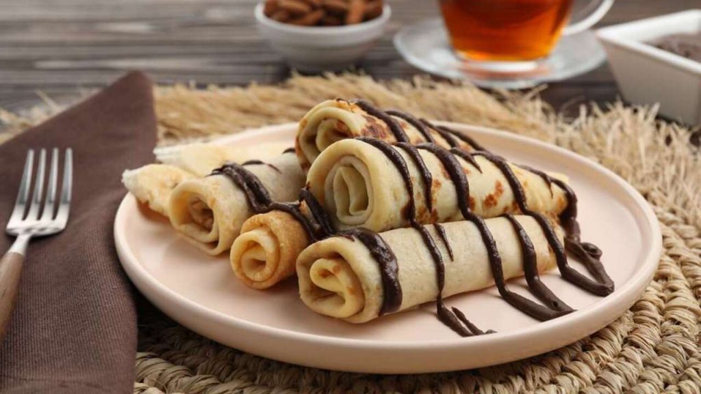 Lahodné palacinky s čokoládovou polevou podávané na drevenom stole