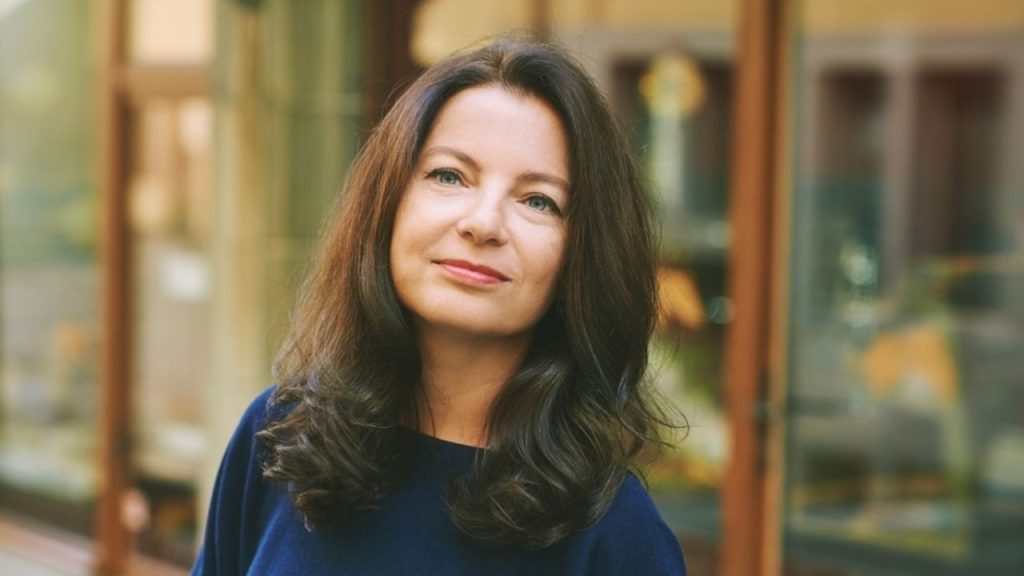 Zrelá žena po päťdesiatke s pokojnou tvárou premýšľajúca o vzťahoch a životných skúsenostiach