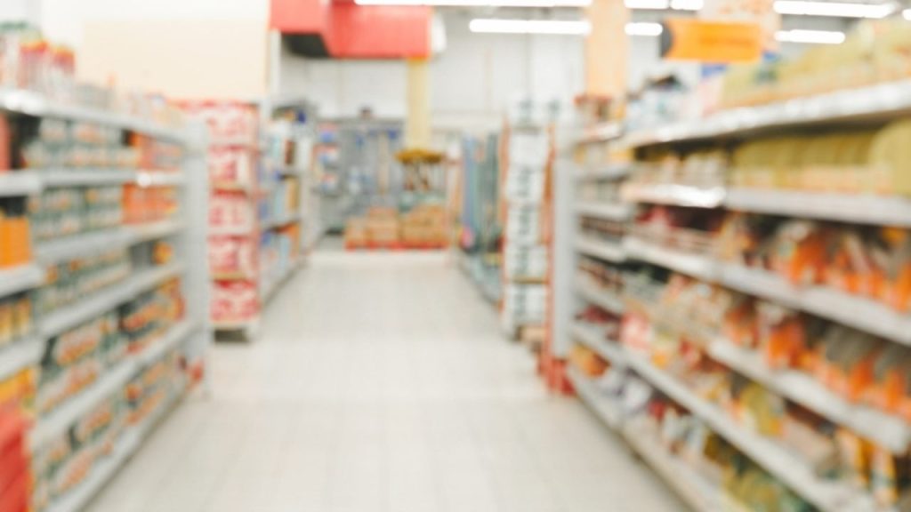 Rozmazané uličky supermarketu s regálmi a umelým osvetlením