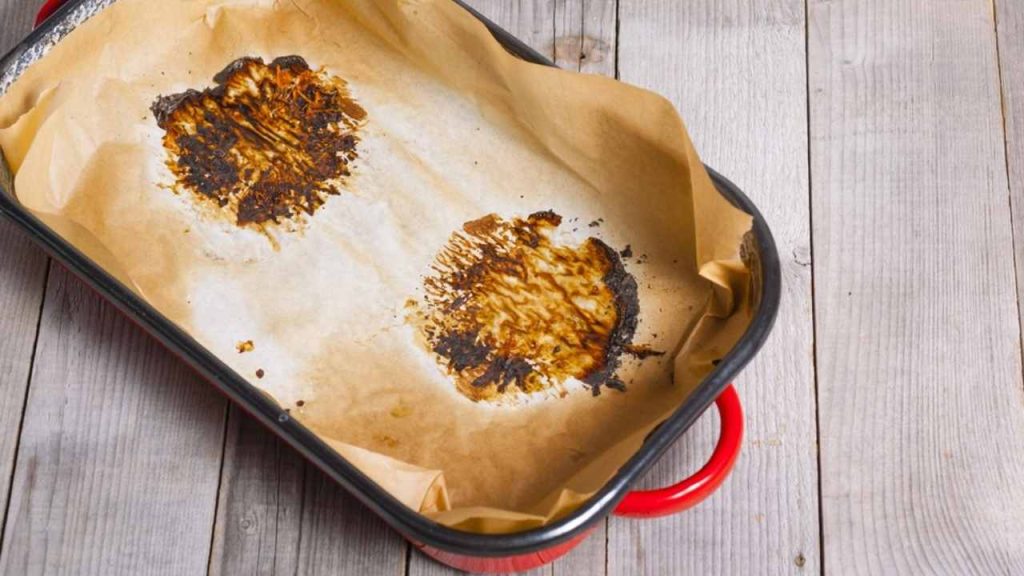 Pripálený papier na pečenie v rúre ako dôsledok príliš vysokej teploty.