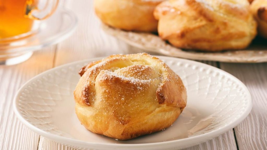 Čerstvo upečený nadýchaný kvasnicový koláč posypaný cukrom