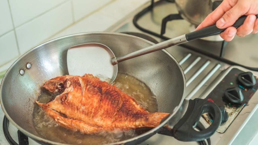 Vyprážanie ryby na panvici v kuchyni