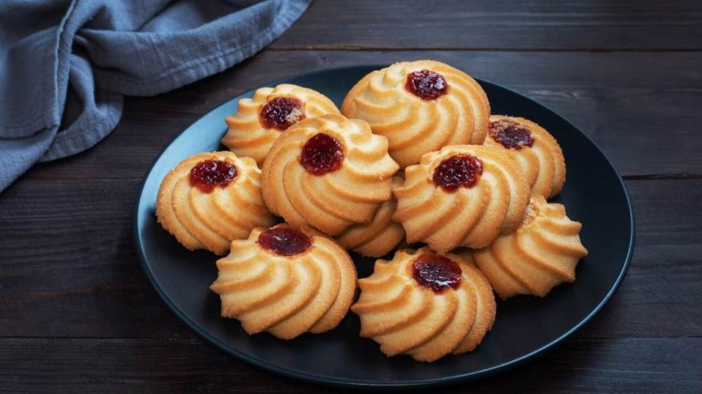 Krehké pudingové sušienky s marmeládou na tmavom tanieri