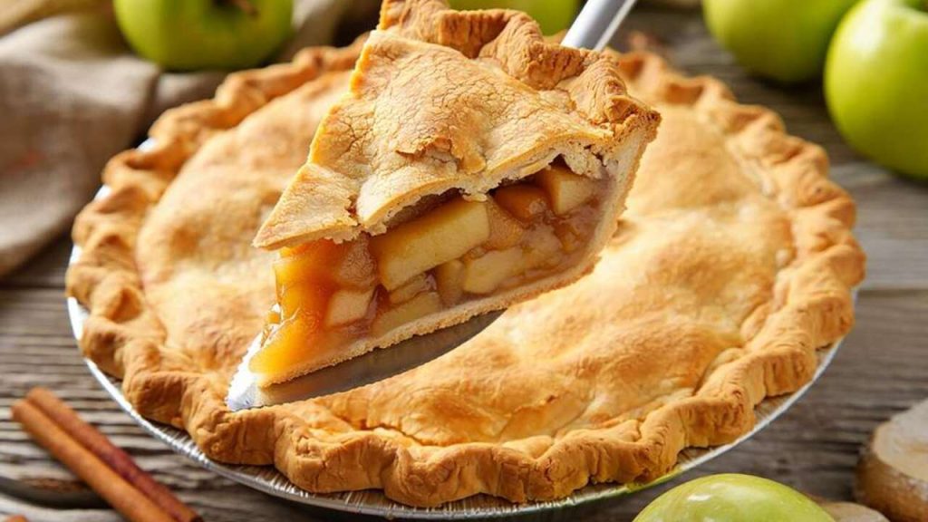 Jablkový koláč s hustou náplňou, z ktorého sa vyberá kúsok lopatkou
