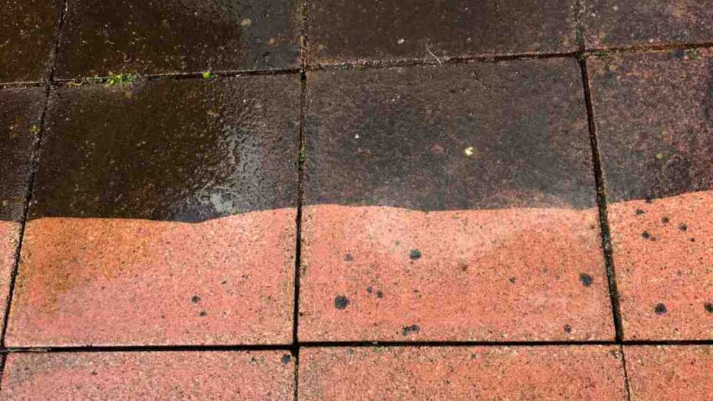 Porovnanie špinavej a vyčistenej zámkovej dlažby po zime s tmavými mapami a škvrnami