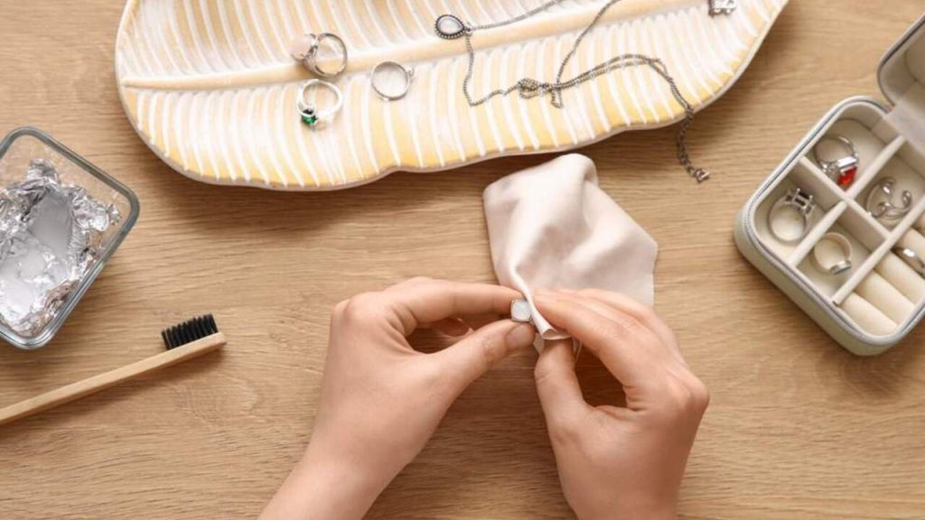 Domáce čistenie strieborných šperkov leštením mäkkou handričkou na drevenom stole