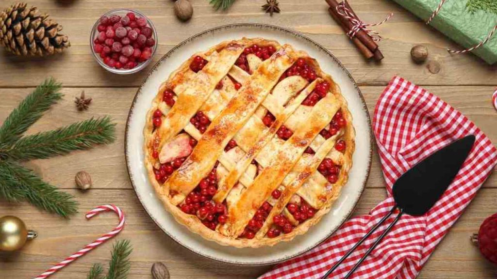 Upečený krehký koláč s brusnicami a mriežkou z cesta na drevenom stole