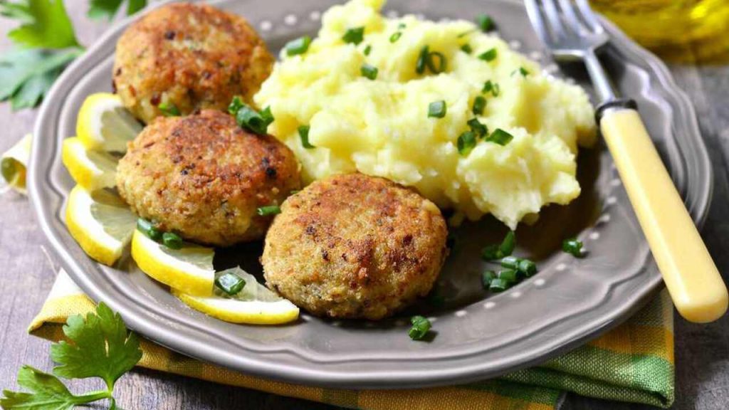 Mleté fašírky podávané so zemiakovou kašou a citrónom na tanieri