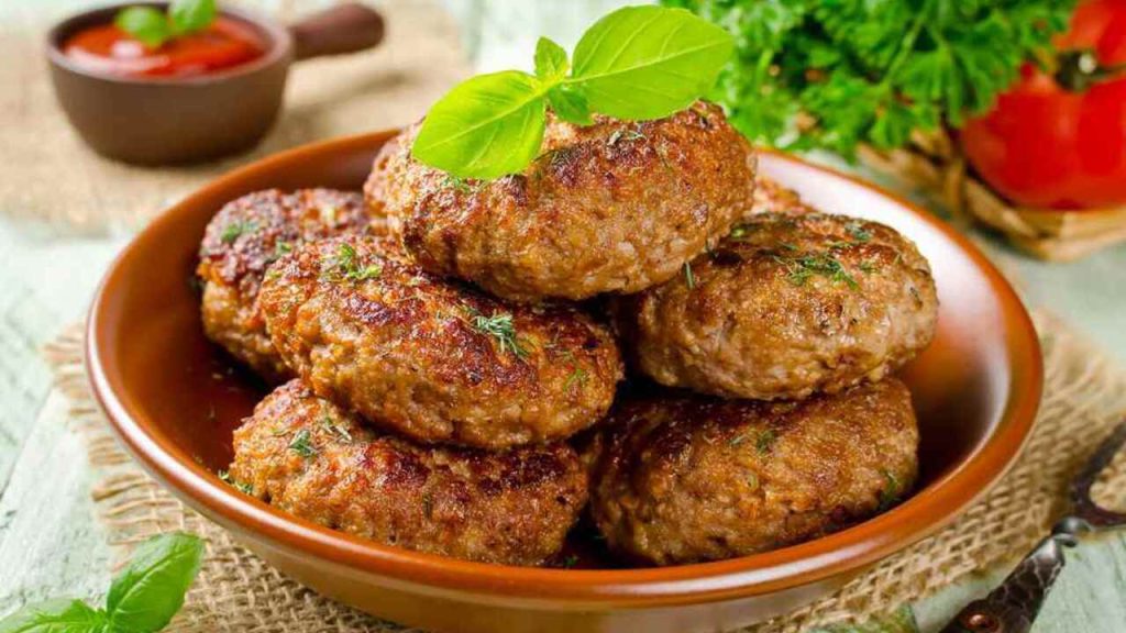 Mleté fašírky dozlatista opečené, nadýchané a šťavnaté, servírované v miske s bylinkami