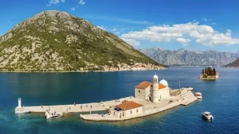 Ostrov svätého Juraja a kostol Panny Márie na skale v Peraste, Čierna Hora. Ostrov Panny Márie na skale a kostol v Peraste na brehu zátoky Boka Kotor (Boka Kotorska), Čierna Hora, Európa.