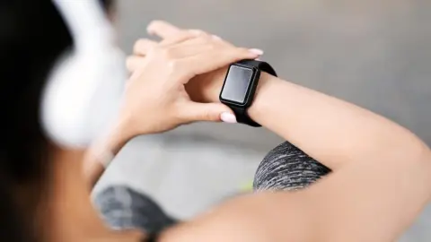 Fitness tracker. Nepoznateľná žena kontroluje svoj športový pokrok na inteligentných hodinkách po tréningu vonku, pohľad cez rameno so selektívnym zaostrením