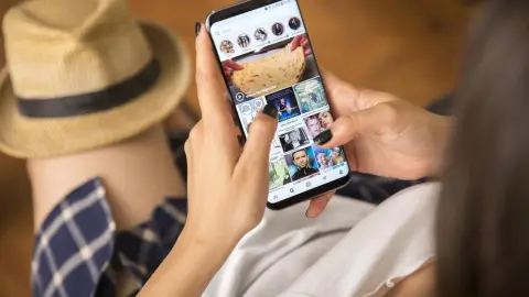 Žena drží v ruke smartfón a prehliada obsah v aplikácii