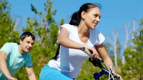 Muž a žena jazdia na bicykli v prírode počas slnečného dňa