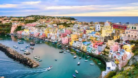 Panoráma ostrova Procida s farebnými domčekmi pri prístave Marina di Corricella v Taliansku.