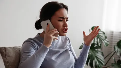 Nahnevaná žena telefonuje a gestikuluje počas rozhovoru