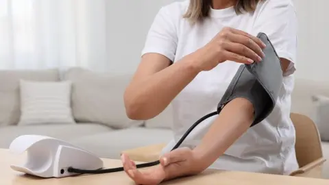 Žena si doma meria krvný tlak pomocou digitálneho tlakomeru