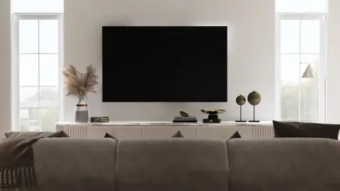 Moderná obývačka s veľkým televízorom na stene, ktorý dominuje priestoru.
